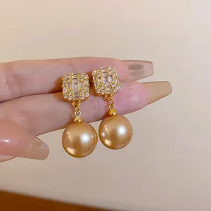 Exquisite Nahaufnahme von Champagner-Perlenohrringen mit eleganten, quadratischen Diamantkronen