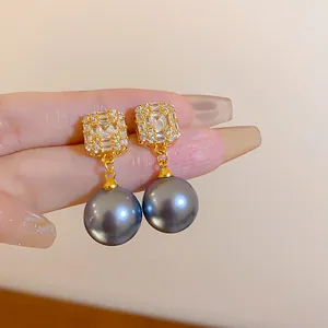 Nahaufnahme eleganter Silberohrringe mit quadratischen Kristallen und grauen Perlen