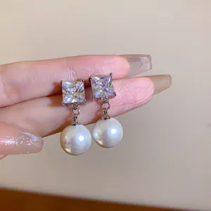 Detailaufnahme eleganter Silberstecker mit quadratischem Kristall und weißer Perle