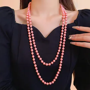Close-up of elegant double-strand pink pearl necklace worn over black dress