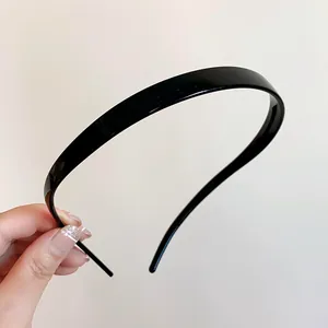 Gros plan sur un serre-tête en acrylique noir brillant montrant son design élégant