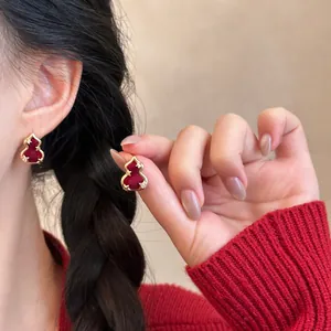 Detailed view of elegant gold-plated red gourd stud earrings with zircon accents.