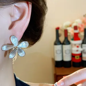 Boucle d'oreille élégante en forme de fleur d'argent avec texture en métal brossé