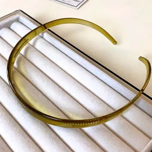 Gros plan sur un serre-tête en acrylique vert olive translucide au design minimaliste élégant