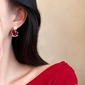 Close-up of elegant red velvet rocking horse earrings with pearls and gold plating