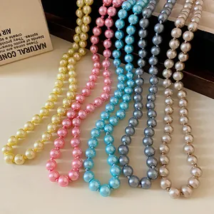 Close-up detail of multi-colored long pearl necklaces in pink, blue, and yellow