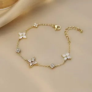Detailed view of gold plated chain bracelet with sparkling zircon flower charms and adjustable link