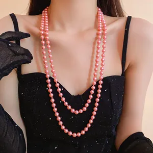 Close-up of an elegant double-strand pink pearl necklace worn with a black dress