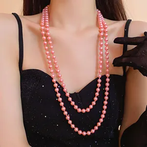 Elegant close-up of a double strand long pink pearl necklace worn with a black dress