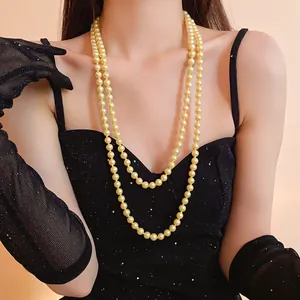 Detail of elegant long double-layer pearl necklace worn with a vintage black dress.