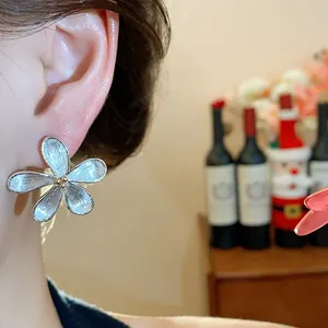 Gros plan détaillé d'une boucle d'oreille en forme de fleur argentée texturée chic