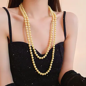 Elegant double-strand long pearl necklace on model in black dress - detail view