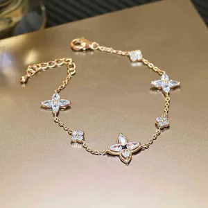 Detailed macro view of a rose gold plated bracelet with sparkling zircon flower motifs.