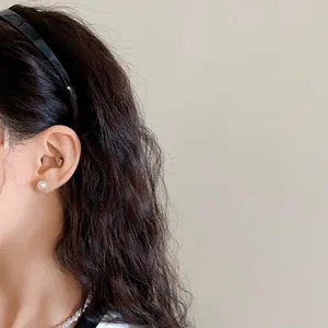 Vue détaillée d'un serre-tête minimaliste noir ondulé en acrylique sur cheveux noirs