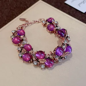 Elegant vintage rose gold bracelet featuring purple cabochon beads and rhinestone leaf accents