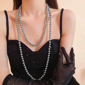 Elegant long grey pearl necklace shown in detail on a female model with black mesh gloves.