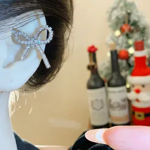 Elegante ear cuff con fiocco di zirconi per orecchie senza buco in un'atmosfera festosa.