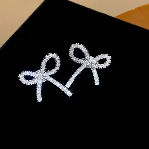 Orecchini a clip a forma di fiocco in zirconia lucida su sfondo di velluto nero liscio