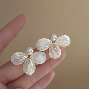 Elegant floral stud earrings featuring natural mother-of-pearl petals and central white pearls