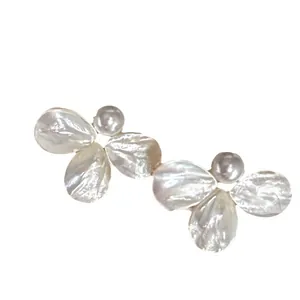 Elegant mother-of-pearl flower earrings with central pearls on white background