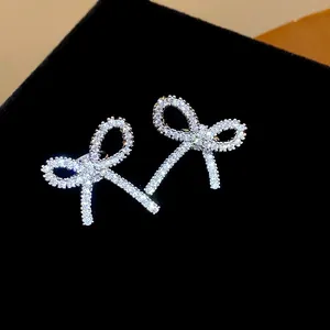 Dettaglio macro di clip per orecchie a fiocco con zirconi scintillanti su fondo in velluto