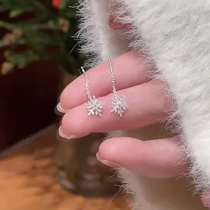Close-up detail of silver snowflake drop earrings decorated with small crystals
