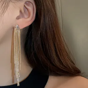 Macro view of the long metallic gold tassels on these fashionable fringe drop earrings