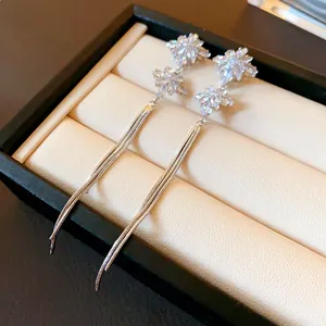 Close-up detail of elegant silver snowflake dangling earrings featuring sparkling crystals