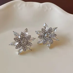 Close-up of elegant snowflake-shaped stud earrings with clear sparkling crystals