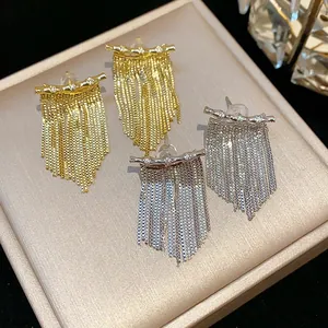Gros plan d'élégantes boucles d'oreilles à pampilles en zircon plaqué or et argent sur support