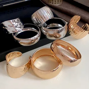Set di bracciali a polsino in metallo oro e argento con texture martellata e rigata