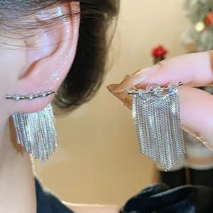 Détail de boucles d'oreilles à pompons plaquées or 14K avec pierres de zircon