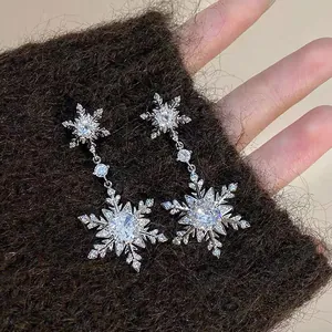Detail view of elegant silver snowflake dangle earrings with sparkling crystal rhinestones