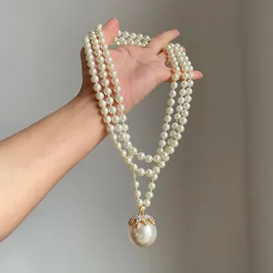 Primo piano di una collana di perle vintage a più strati con ciondolo di strass