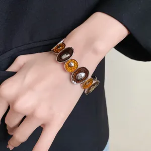 Dettaglio del bracciale vintage in smalto a cerchi irregolari su un polso femminile