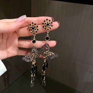 Detailaufnahme von Vintage-Schmetterlings-Ohrringen mit schwarzen Kristallanhängern