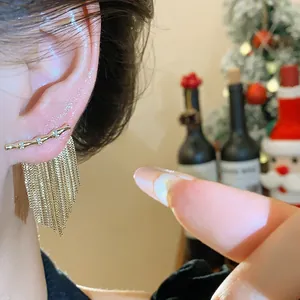 Gros plan détaillé de boucles d'oreilles à pampilles en zircon plaqué or 14 carats.