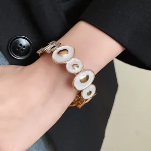 Dettaglio macro del bracciale vintage in smalto con cerchi irregolari dorati