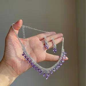 Elegant silver-tone necklace and earring set with purple teardrop crystals and rhinestones.