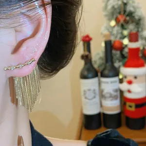 Gros plan exquis d'élégantes boucles d'oreilles à pompons plaquées or 14K avec zircons brillants
