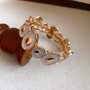 Bracciale vintage dorato con cerchi irregolari intarsiati in smalto bianco chic