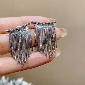 Vue macro détaillée d'élégantes boucles d'oreilles à pompon en zircon avec design en bambou