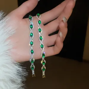 Detail shot of elegant bracelets with green oval stones and sparkling crystals.