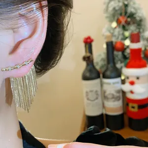 Gros plan montrant l'effet de port d'élégantes boucles d'oreilles 14K plaquées or et zircons