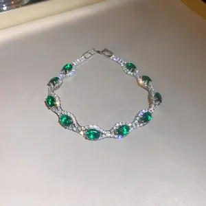 Elegant palace style emerald crystal oval bracelet featuring intricate diamond-set detailing.