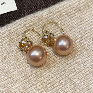 Gros plan détaillé de boucles d'oreilles cœur en or de style français avec perles champagne
