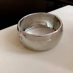 Elegante bracciale a fascia larga in metallo martellato color argento con cerniera