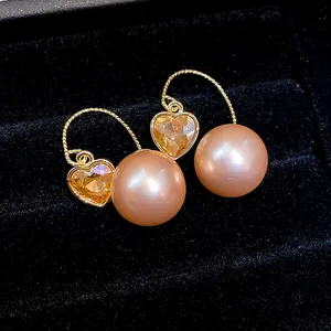 Vue macro détaillée de boucles d'oreilles françaises en cristal de cœur et perle de pêche