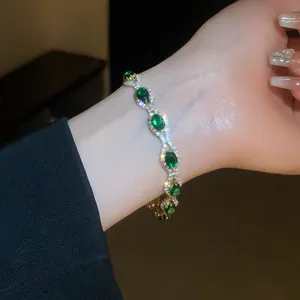 Close-up of emerald green oval crystal bracelet with pavé diamonds on wrist
