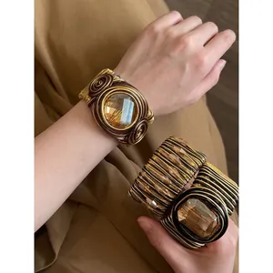 Bracciale rigido geometrico in resina con avvolgimento in filo dorato per donna